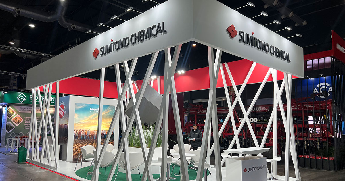 Stand industrial con maquinaria pesada en exhibición y zona de reunión técnica en una feria del sector energético